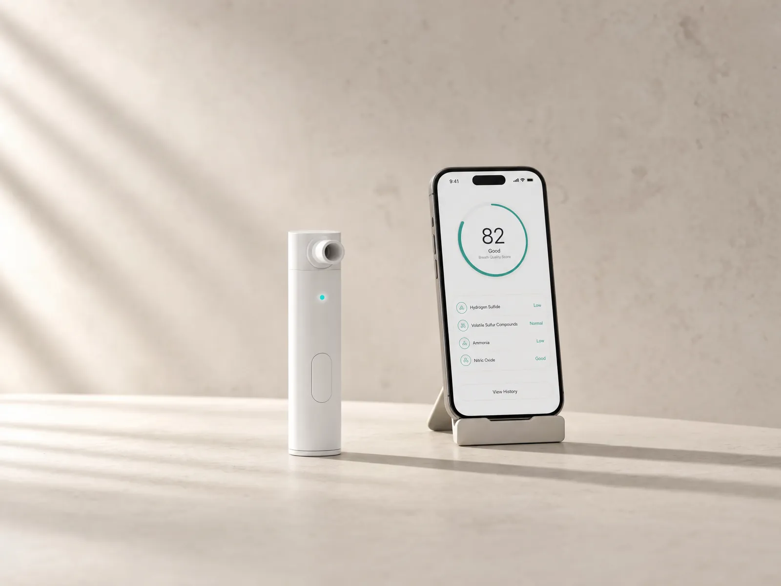 A handheld breath-analysis device beside a phone showing its breath score